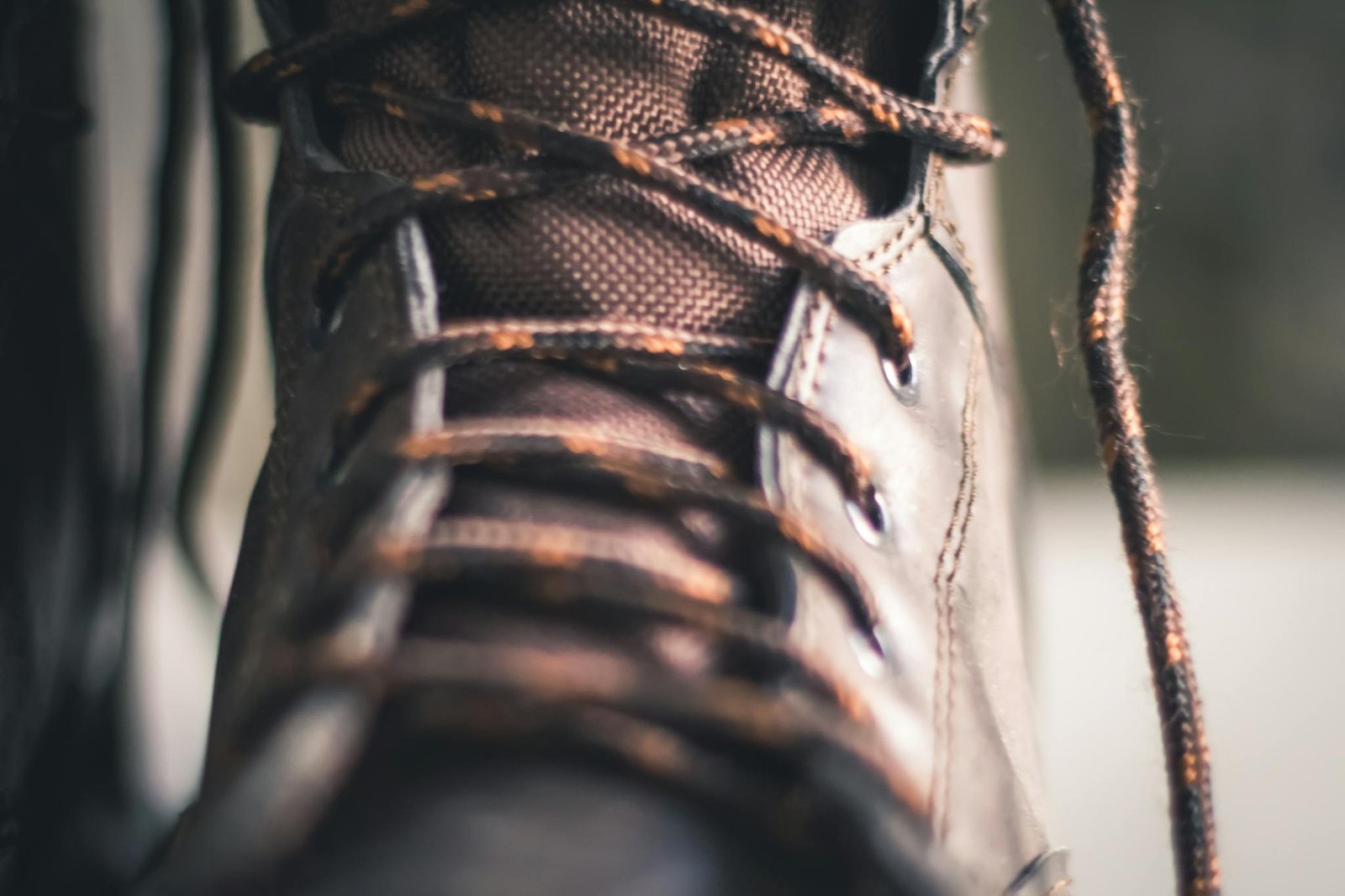 Detailed close-up of a brown leather boot with intricate lacing, highlighting texture and craftsmanship.